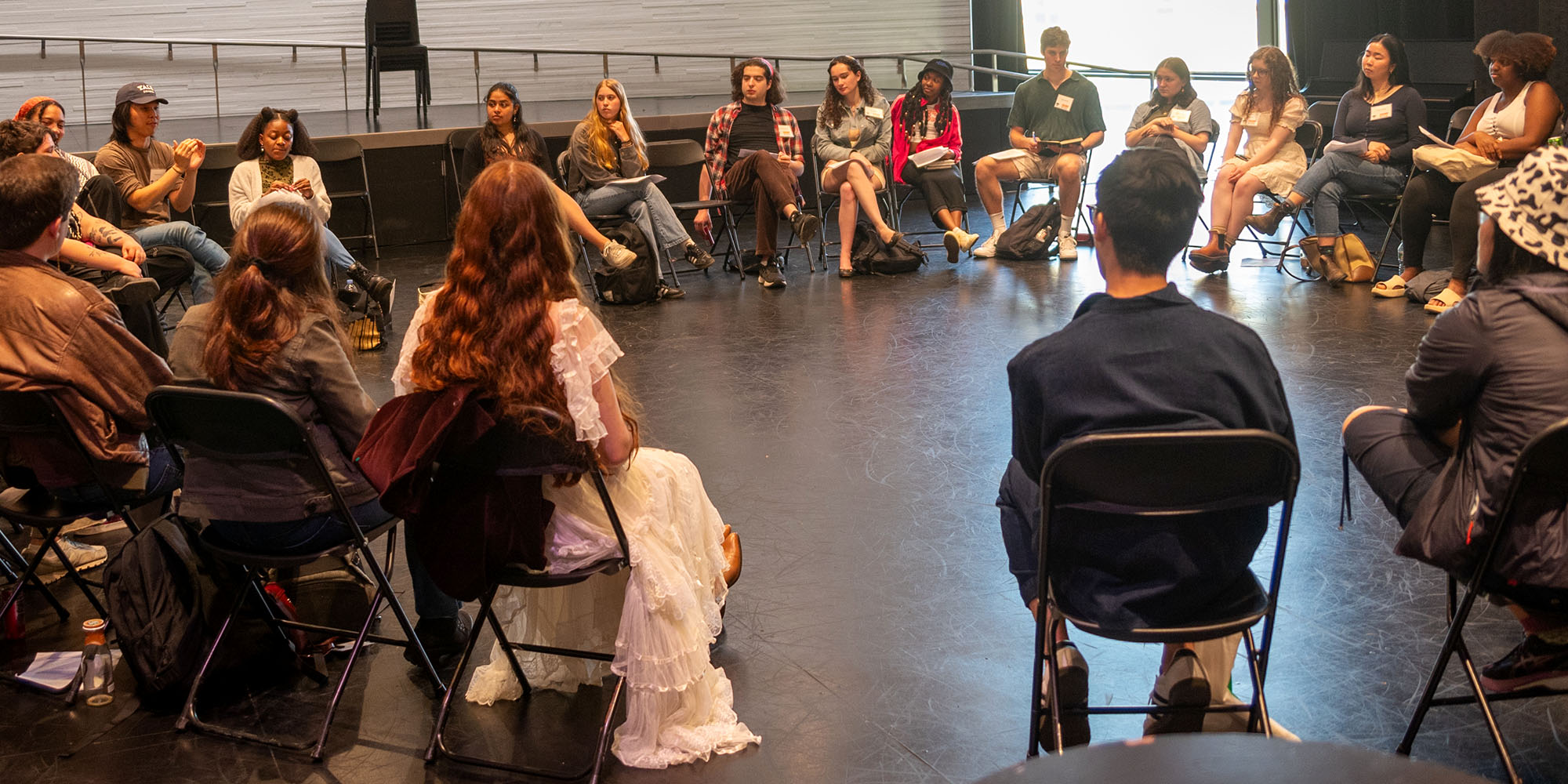 A group of people sit at chairs and have a conversation