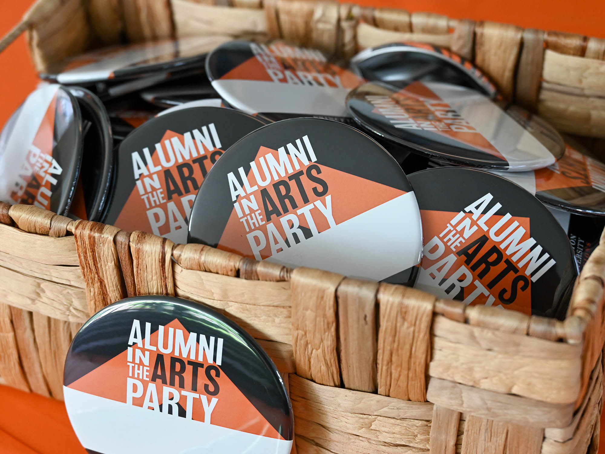 Basket full of Alumni in the Arts Party buttons.