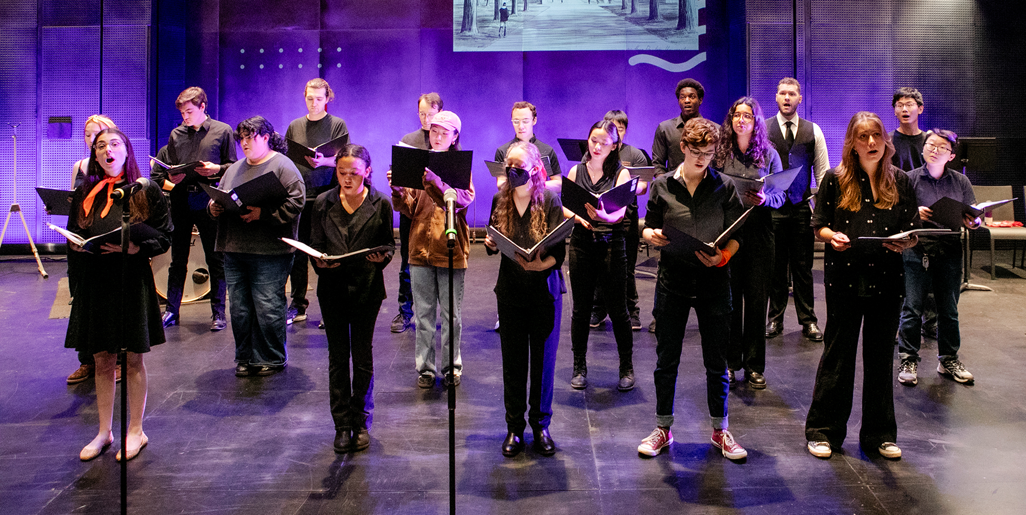 A choral group sings onstage.