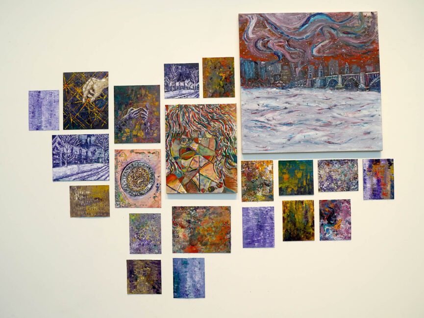 A collection of abstract colorful paintings hang on the wall of a gallery.