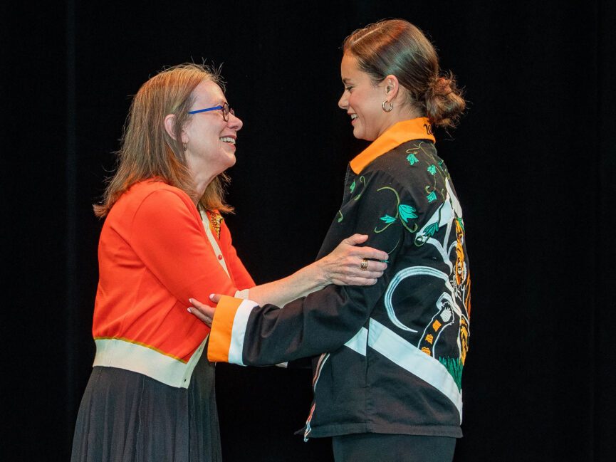 Two people embrace on stage.